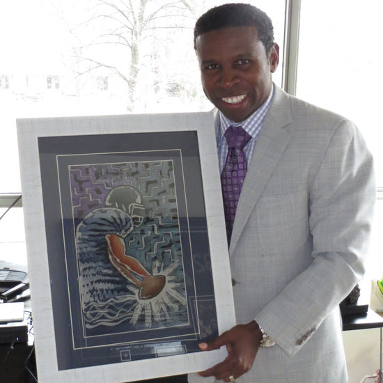 Man in a suit holding a framed artwork of a tiger in a maze.